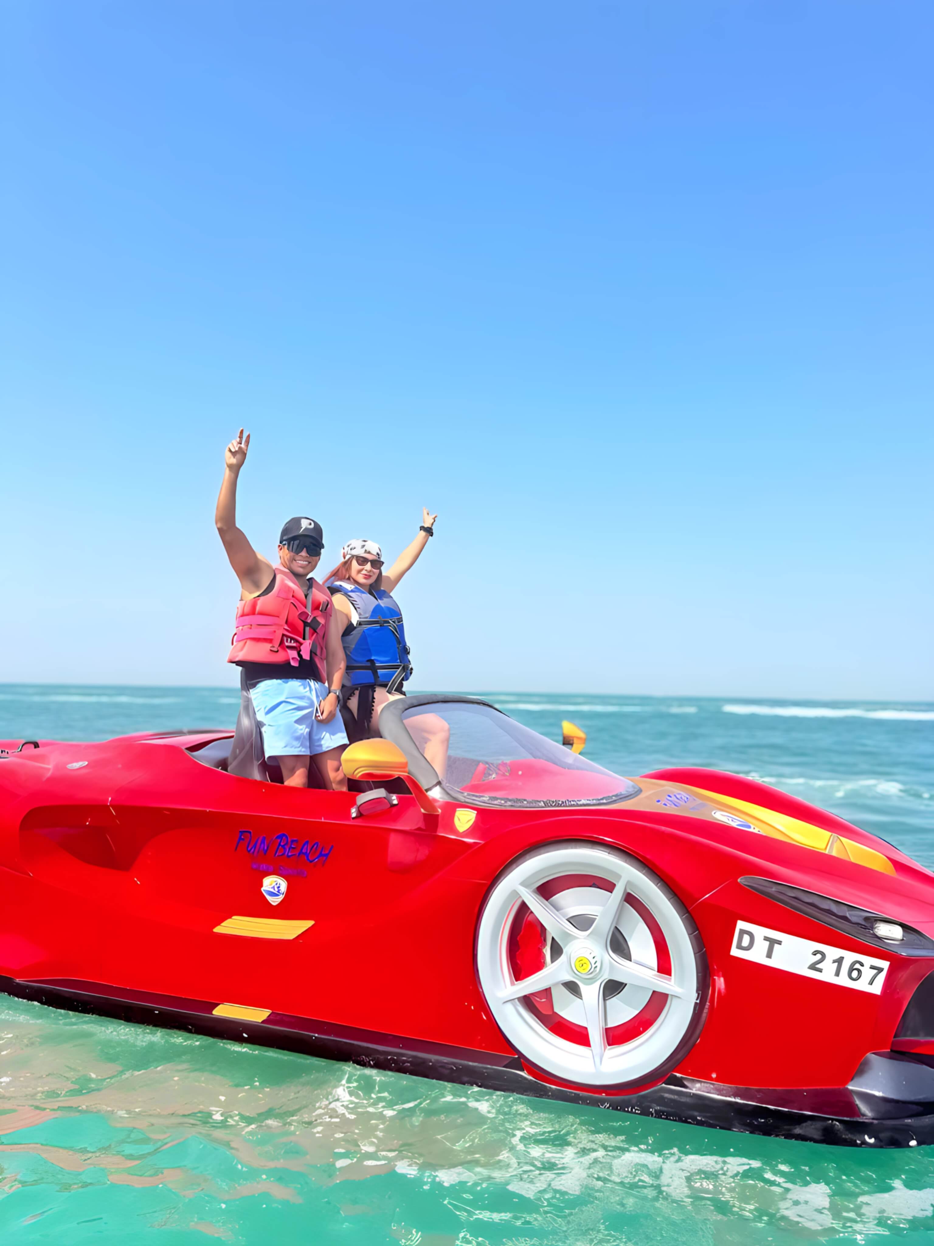Couple celebrating on a red Fun Beach jet car in Dubai